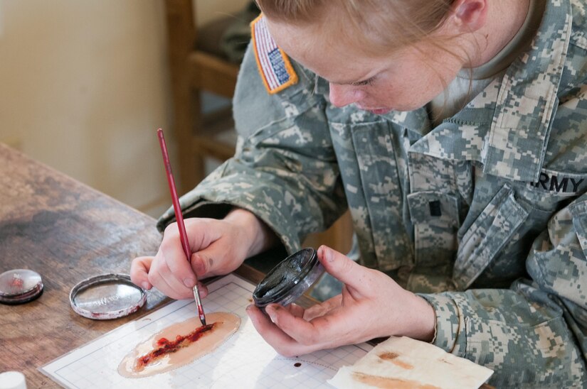 Army Reserve 1st Lt. Rebecca Milligan, of the Effects and Enablers Team, which is augmenting the 84th Training Command's Combat Support Training Exercise and the Army Medical Command’s Global Medic Exercise headquartered out of Fort Hunter Liggett, California, paints a simulated injury for medical professionals to train on during mass casualty scenarios on Camp Roberts, California, July 16, 2017.