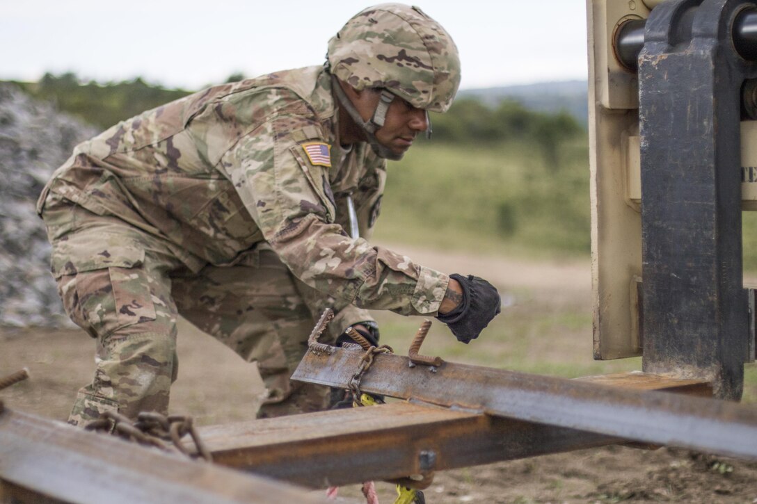 U.S. Army Reserve Soldier, Staff Sgt. Matthew Chisholm, Waycross, Ga., 381st Engineer Company, Tifton, Ga., helps prepare movement of construction materials during Resolute Castle 17 at Cincu, Romania, July 15, 2017. Chisholm, who works in Law, traveled from his home in Way Cross, Ga., with his unit to help complete construction of a new training facility that will provide Allied forces the opportunity to prepare for potential conflict. The entire operation is led by U.S. Army Reserve engineers, who moved Soldiers and equipment from the U.S. to Romania over a period of several weeks to complete the training facility. Resolute Castle improves interoperability, enhances confidence and security assurance between partner nations, while improving infrastructure, capability and capacity at select locations throughout Europe. (U.S. Army Reserve photo by Staff Sgt. Felix R. Fimbres)