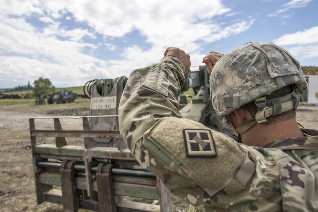 U.S. Army Reserve Soldier, Sgt. Byron Haynes, 733rd Engineer Company, Greenville, S.C. guides a U.S. Army Reserve Soldier, with hand signals, to move a pallet of cinder blocks during Resolute Castle 17 at Cincu, Romania, July 15, 2017. Haynes, who is a highway inspector, in South Carolina, traveled to Romania with his company to help complete construction of a new training facility that will provide Allied forces the opportunity to prepare for potential conflict. The entire operation is led by U.S. Army Reserve engineers, who moved Soldiers and equipment from the U.S. to Romania over a period of several weeks to complete the training facility. Resolute Castle improves interoperability, enhances confidence and security assurance between partner nations, while improving infrastructure, capability and capacity at select locations throughout Europe. (U.S. Army Reserve photo by Staff Sgt. Felix R. Fimbres)