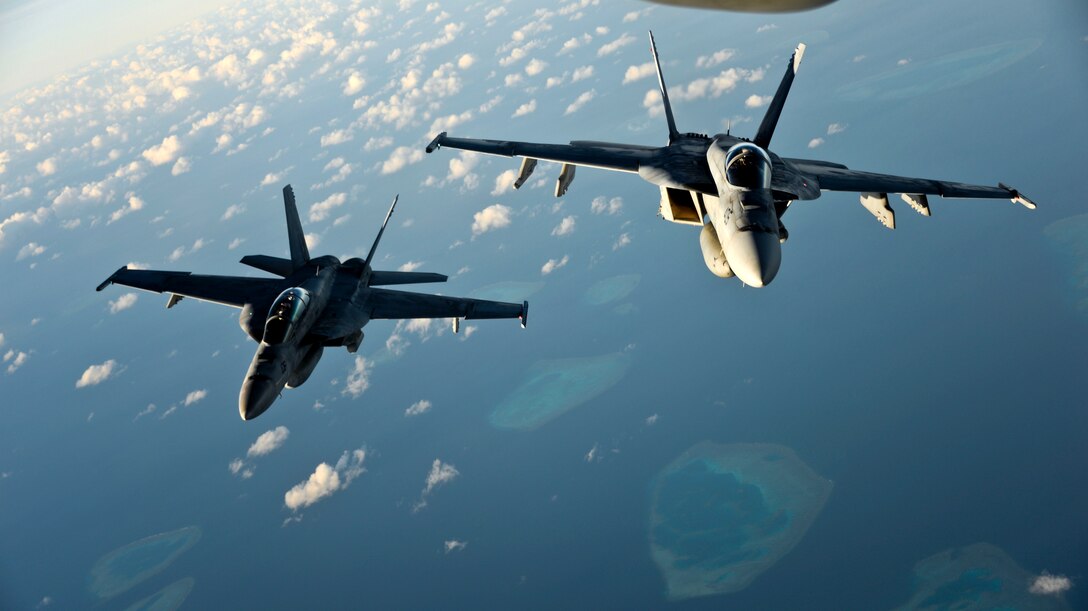 Two Navy F/A-18 Super Hornets position themselves behind a KC-10 Extender aircraft to refuel over the Pacific Ocean, July 14, 2017. Air Force photo by 2nd Lt. Sarah Johnson