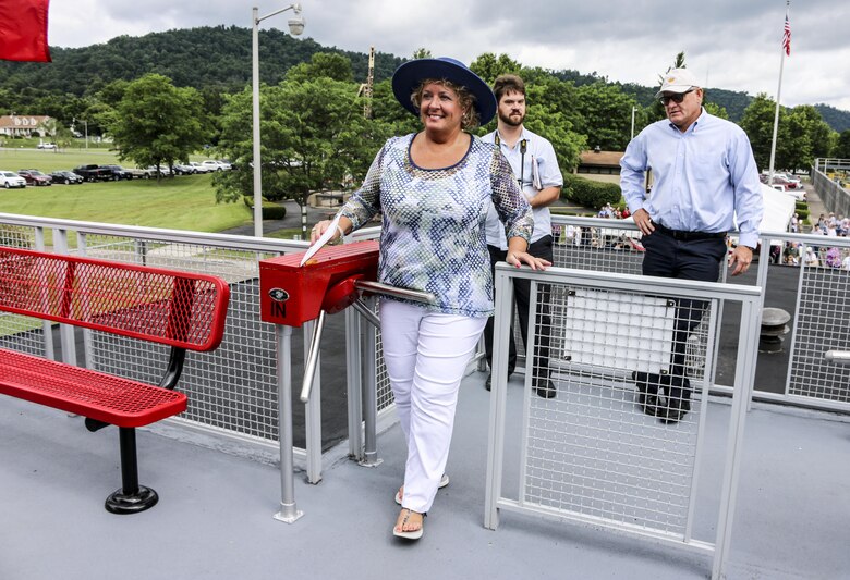 As one of the first visitors at the newly renovated visitors center, Ms. Hoagland, the wife of Frank Hoagland, Ohio 30th District Senator (far right), goes through the turnstile at Hannibal Lock and Dam.