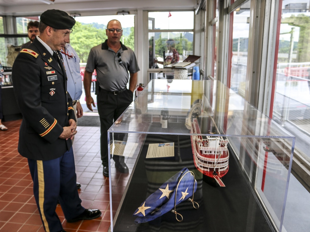 Col. John Lloyd, commander U.S. Army Corps of Engineers Pittsburgh District, looks at the model-sized replica of the stream-powered Maneuver Boat 35, which was used to set the wicket-type gates in the early 1970s while Lockmaster, Scott Edgar presents the exhibits. 