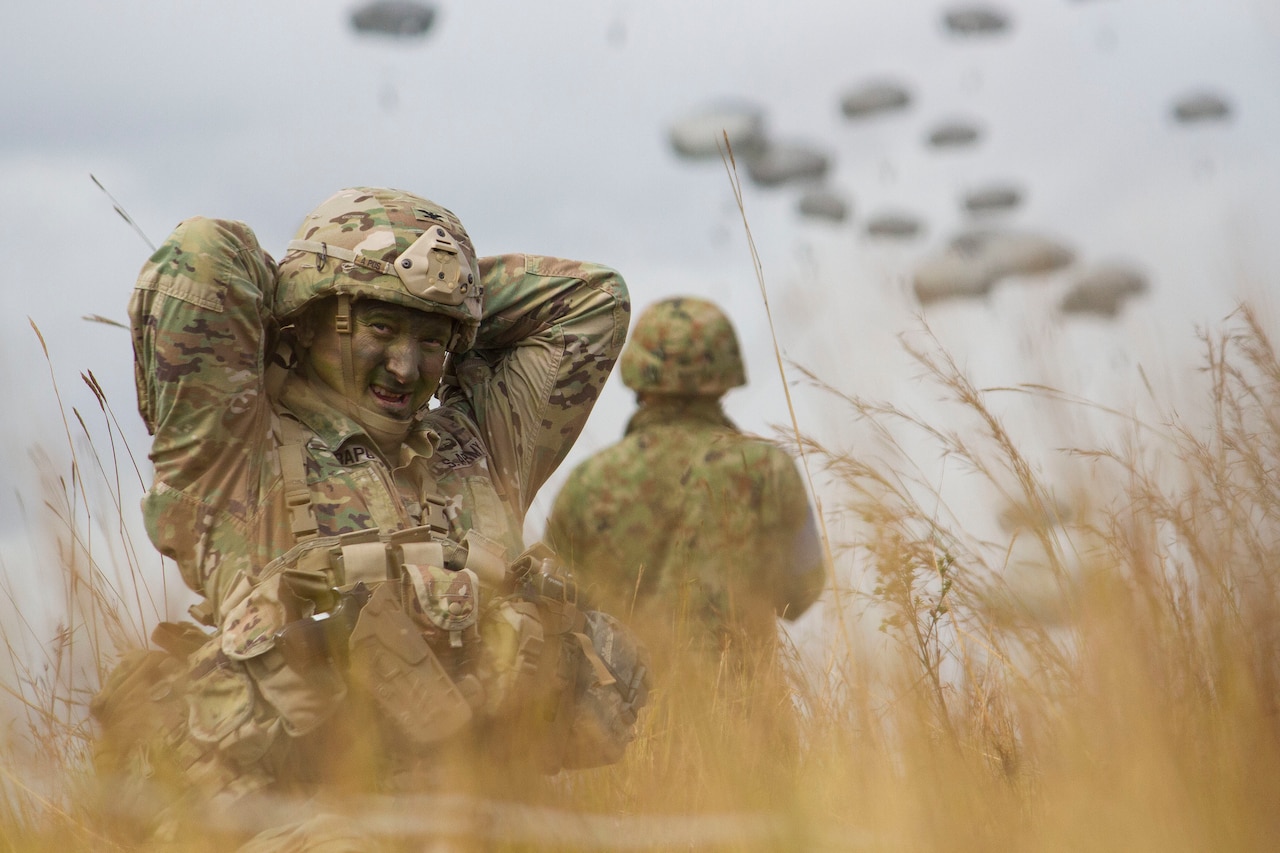 Army Col. Jeffrey Crapo, commander of the 4th Infantry Brigade Combat Team, 25th Infrantry Division, adjusts his gear after landing at Drop Zone Kapyong near Williamson Airfield at Shoalwater Bay Training Area, Australia, July 13, 2017. Washington Army National Guard photo by Staff Sgt. Rory Featherston