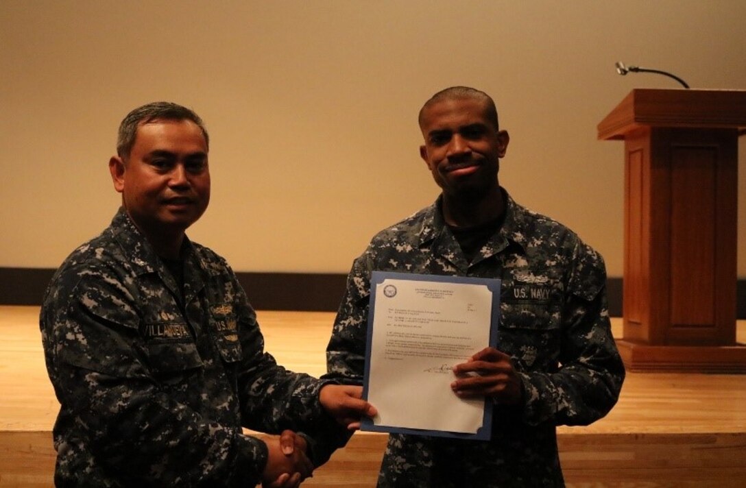 DLA Distribution Yokosuka, Japan, commanding officer Navy Cmdr. Nolasco Villanueva advances Petty Officer Kevin R. Craig Jr. to Second Class Petty Officer.