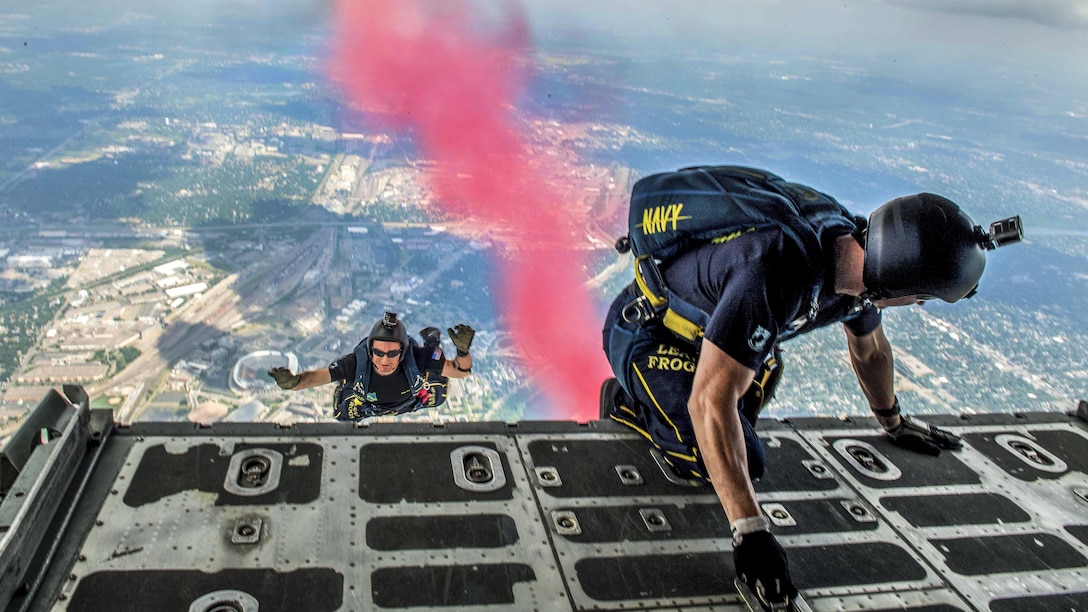 Members of the Leap Frogs, the Navy's parachute team, jump from a C-130 Hercules cargo plane for a skydiving demonstration above downtown Minneapolis, Minn., July 15, 2017. Navy photo by Petty Officer 3rd Class Kelsey L. Adams