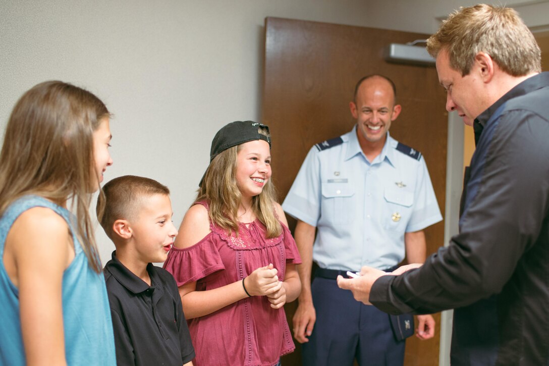Magician Mike Super performs a card trick for Col. E. John Teichert, 11th Wing and Joint Base Andrews commander, and family at JBA, Md., July 21, 2017. During his 17-installation tour, Super said that he was looking forward to meeting Airmen and families, learning more about Air Force career fields and spending time on installations. (U.S. Air Force photo by Senior Airman Delano Scott)
