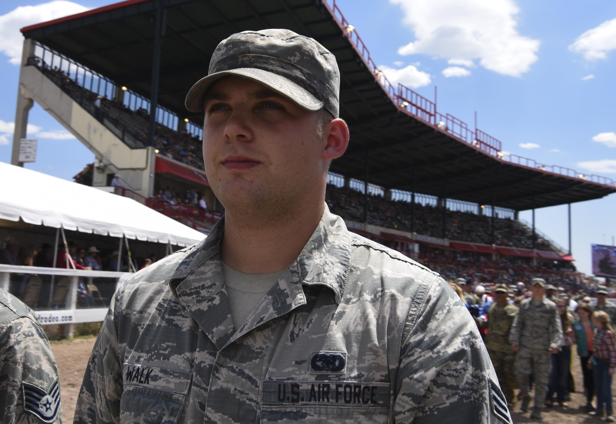 Senior Airman Chris Walk, 90th Logistics Readiness Squadron vehicle maintainer, leads the way for military and community members carrying the American flag during Military Monday at Frontier Park in Cheyenne, Wyo., July 24, 2017. More than 100 volunteers unfurled a massive flag to begin the rodeo’s grand entry ceremony. This year marks the 150th anniversary of F.E. Warren Air Force Base and the city of Cheyenne. The two communities came together to celebrate during the 121st CFD rodeo and festival. (U.S. Air Force photo by Airman 1st Class Braydon Williams)