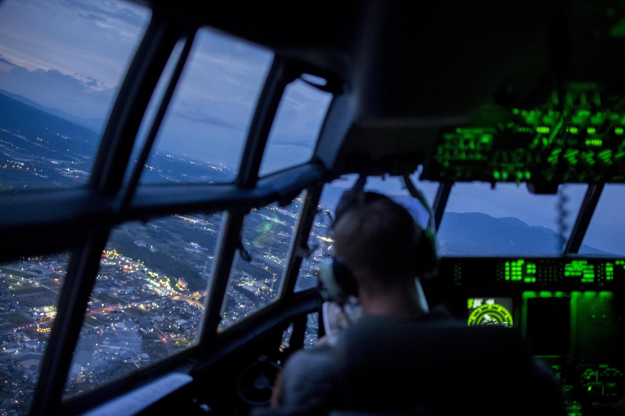 A C-130J Super Hercules pilot with the 36th Airlift Squadron, looks out the aircraft during a routine training mission July 18, 2017, over the Kanto Plains, Japan. The routine training included low level flying, simulated heavy cargo drop and night operations including the loading and unloading of the aircraft. (U.S. Air Force photo by Airman 1st Class Donald Hudson)