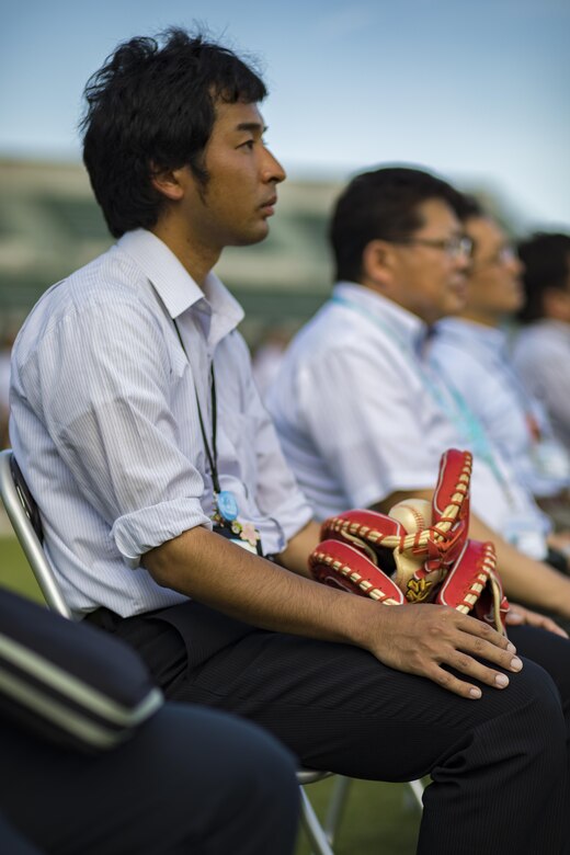A Japanese local holds his baseball gloves as he watches the scoreboard lighting ceremony at Kizuna Stadium in Iwakuni City, Japan, July 19, 2017. Upon completion of the stadium, access will be granted to the people of Iwakuni city and the surrounding towns in the prefecture, to include the service members and their families. (U.S. Marine Corps photo by Cpl. Joseph Abrego)