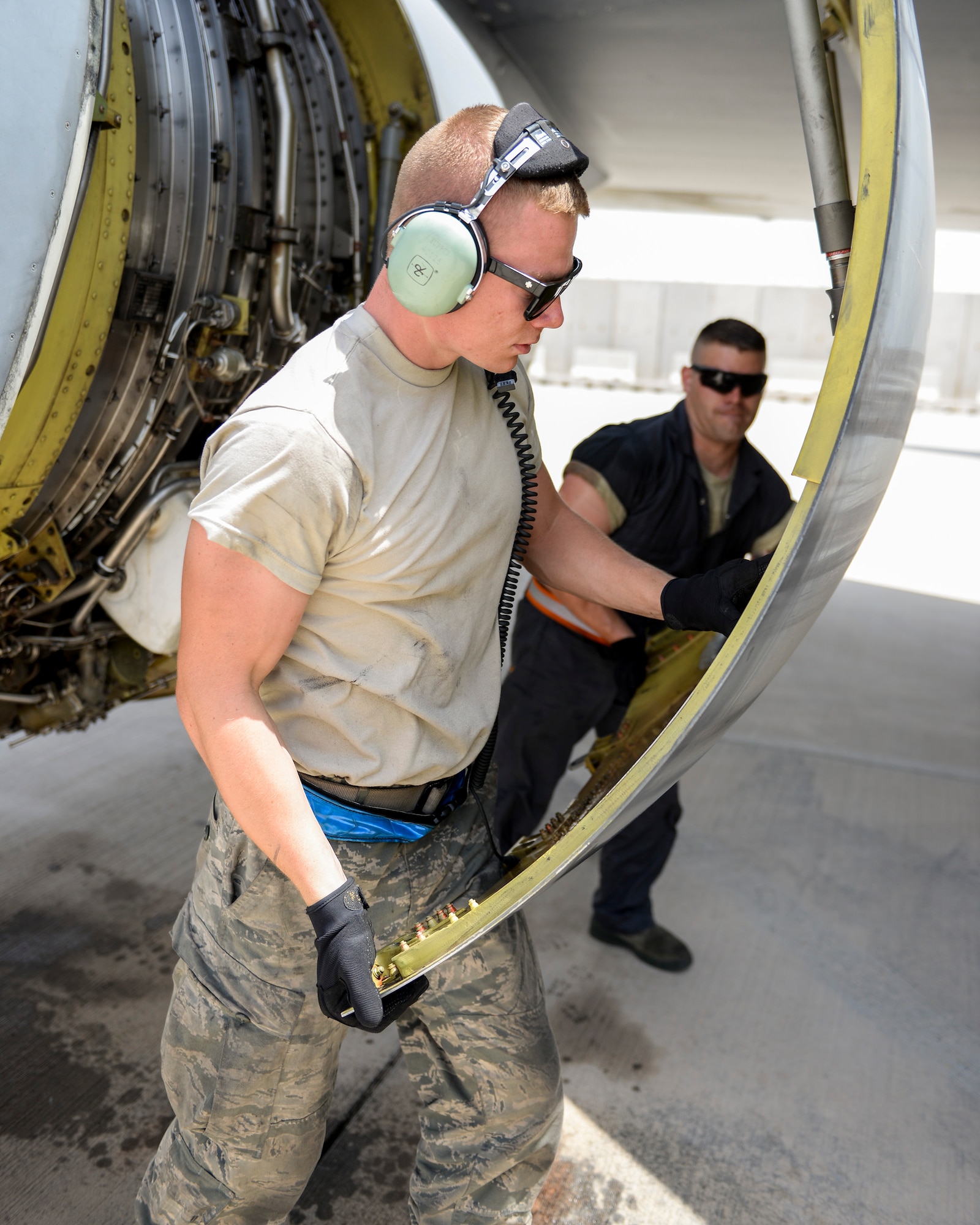 U.S. Air Force Airmen First Class Jared Suppes, foreground, aerospace propulsion apprentice and Staff Sgt. Kyle Craig, background, aerospace propulsion journeyman, close the access panel to one of the engines on a KC-135 after trimming the main engine control on the runway at Al Udeid, Air Base, Qatar, July 7, 2017. The members of the 340th and 22nd EAMUs face minute-by-minute challenges in the sweltering heat on the runway as they work to keep a fleet of KC-135 Stratotankers ready to fly. (U.S. Air National Guard photo by Tech. Sgt. Bradly A. Schneider/Released)