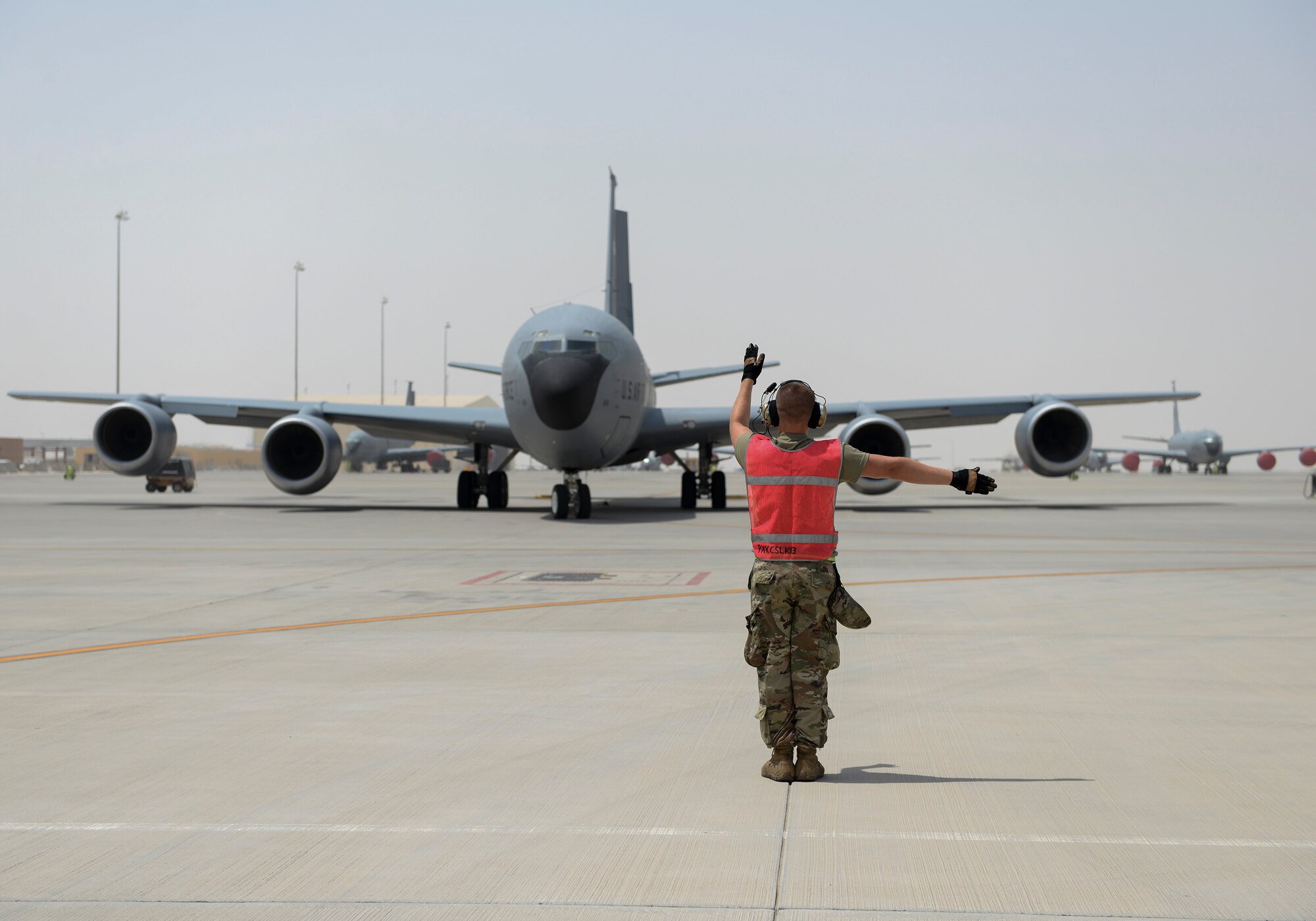 U.S. Air Force Staff Sgt. Benjamin Wolford, crew chief assigned to the 340th Expeditionary Aircraft Maintenance Unit, marshals a KC-135 to the runway at Al Udeid, Air Base, Qatar, July 7, 2017. The members of the 340th and 22nd EAMUs face minute-by-minute challenges in the sweltering heat on the runway as they work to keep a fleet of KC-135 Stratotankers ready to fly. (U.S. Air National Guard photo by Tech. Sgt. Bradly A. Schneider/Released)