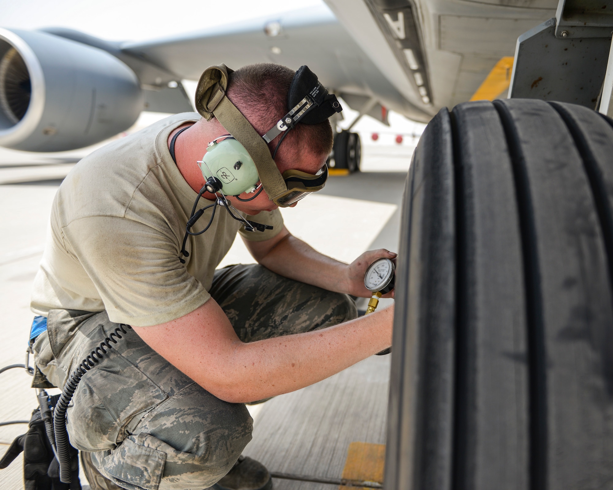 U.S. Air Force Airman 1st Class Jon Nay, crew chief assigned to the 22nd Expeditionary Aircraft Maintenance Unit, checks the air pressure on the landing gear of a KC-135 Stratotanker at Al Udeid, Air Base, Qatar, July 7, 2017. The members of the 340th and 22nd EAMUs face minute-by-minute challenges in the sweltering heat on the runway as they work to keep a fleet of KC-135 Stratotankers ready to fly. (U.S. Air National Guard photo by Tech. Sgt. Bradly A. Schneider/Released)