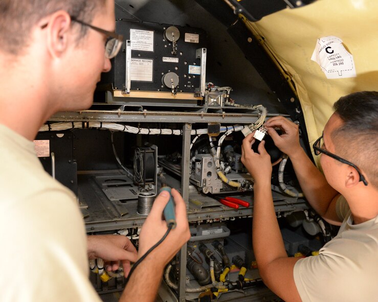 U.S. Air Force Airman 1st Class Thomas Doane, left, guidance and control apprentice, and Senior Airman Tony Nguyen, guidance and control journeyman, both assigned to the 340th Expeditionary Aircraft Maintenance Unit, prepare to solder a power control relay on a KC-135 Stratotanker at Al Udeid, Air Base, Qatar, July 7, 2017. The members of the 340th and 22nd EAMUs face minute-by-minute challenges in the sweltering heat on the runway as they work to keep a fleet of KC-135 Stratotankers ready to fly. (U.S. Air National Guard photo by Tech. Sgt. Bradly A. Schneider/Released)