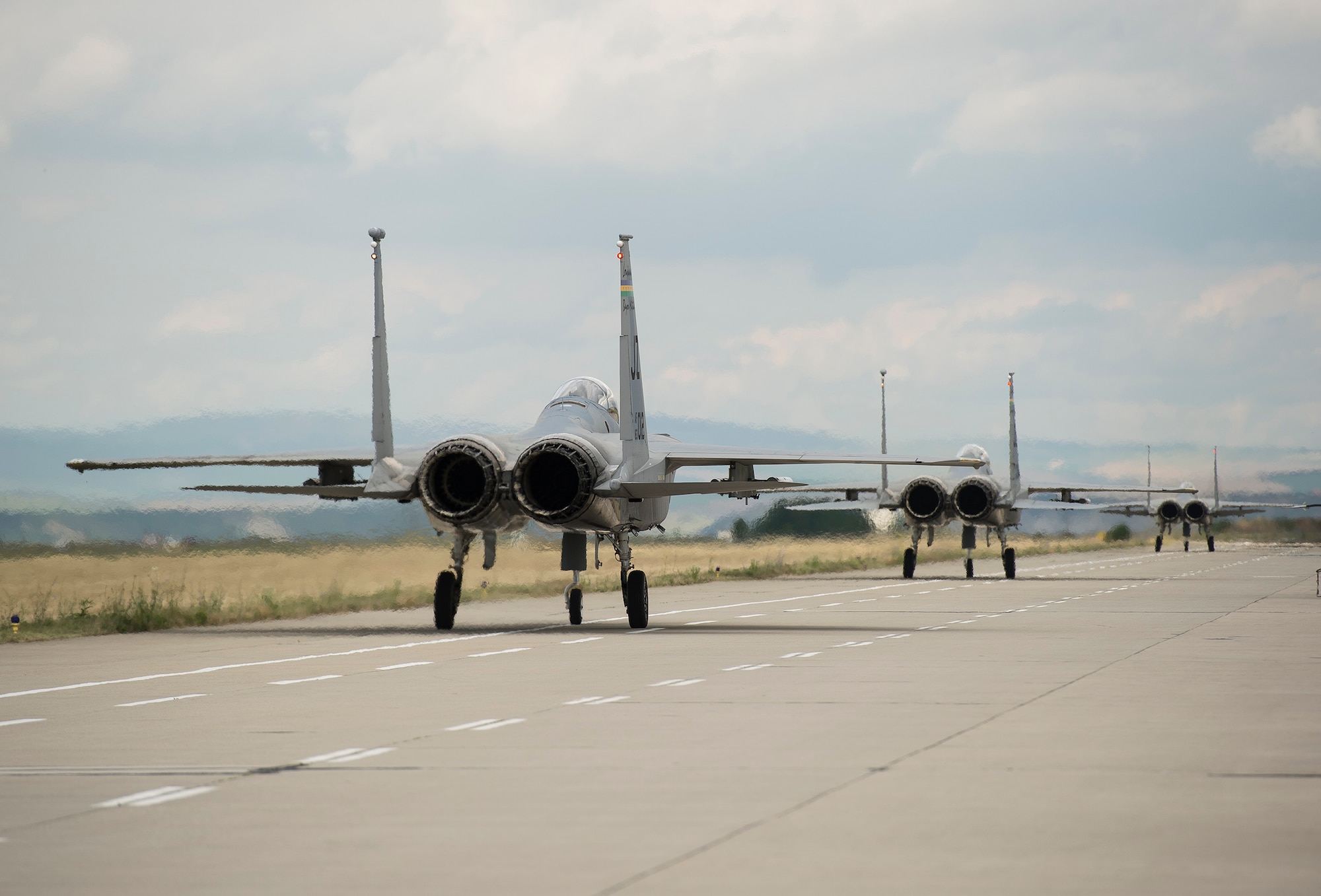 Three F-15C Eagle fighter aircraft from the 159th Expeditionary Fighter Squadron taxi prior to takeoff from Campia Turzii, Romania, July 13, 2017. The squadron is in Romania in support of Operation Atlantic Resolve, an ongoing operation meant to enhance the security of Europe and bolster partnership between NATO allies. (U.S. Air Force photo by Tech. Sgt. Chad Warren)