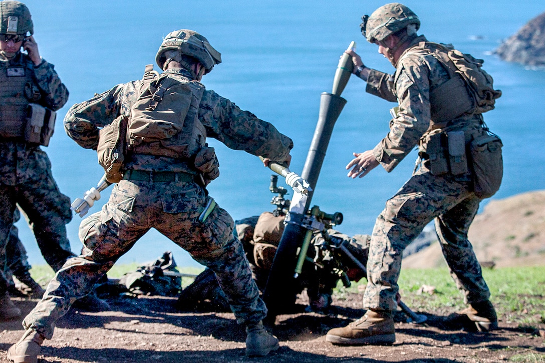 Marine Corps Sgt. William Fabrocini, right, loads a round into the tube of an 81 mm mortar during Exercise Talisman Saber 17 at Townshend Island, Shoalwater Bay Training Area, Australia, July 21, 2017. Fabrocini is a mortarman assigned to Weapons Company, Battalion Landing Team, 3rd Battalion, 5th Marines. Marine Corps photo by Lance Cpl. Stormy Mendez