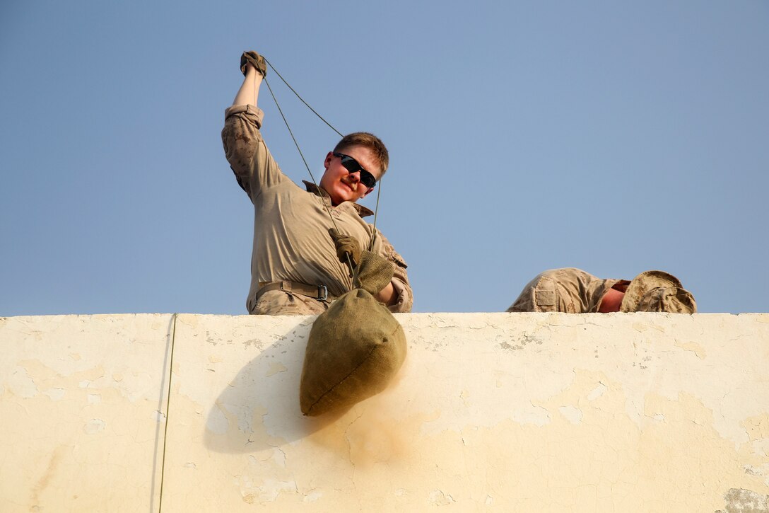 A Marine raises a sandbag to fortify the building during Operation Maiwand Four at Camp Shorserack, Afghanistan, July 14, 2017. The Marine is assigned to Task Force Southwest, which assisted Afghan defense and security forces to clear insurgents from the Nawa district. Marine Corps photo by Sgt. Lucas Hopkins