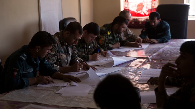 Afghan National Defense and Security Force partners take a map reading test at Bost Airfield, Afghanistan, July 16, 2017. U.S. Marine advisors with Task Force Southwest conducted a three-week map reading class focusing on terrain association, plotting and finding grid coordinates on a map. (U.S. Marine Corps photo by Justin T. Updegraff)