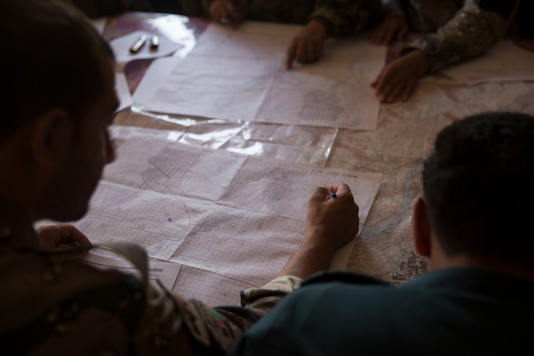 An Afghan policeman locates a terrain feature using a six-digit grid during a map reading test at Bost Airfield, Afghanistan, July 16, 2017. U.S. Marine advisors with Task Force Southwest conducted a three-week map reading class focusing on terrain association, plotting and finding grid coordinates on a map. (U.S. Marine Corps photo by Justin T. Updegraff)