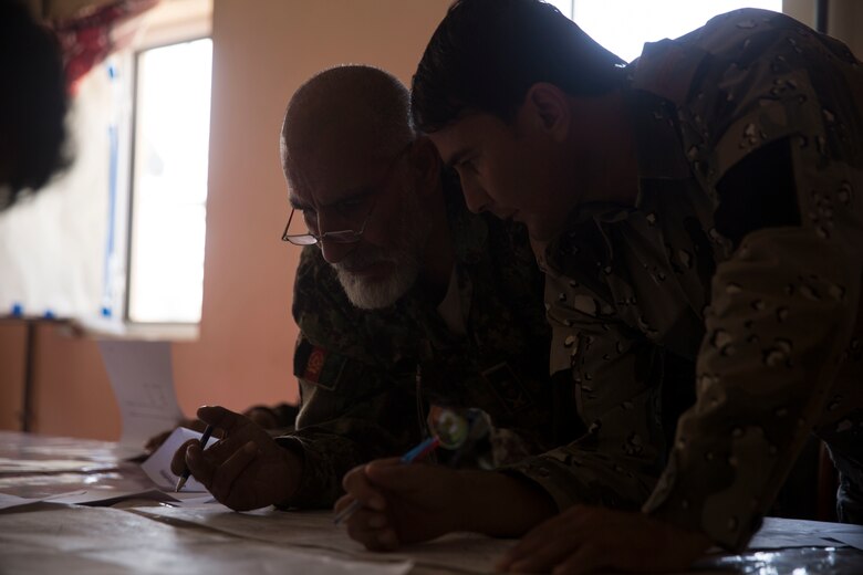 Afghan National Defense and Security Force partners create a six-digit grid based off of a given terrain feature during a map reading test at Bost Airfield, Afghanistan, July 16, 2017. U.S. Marine advisors with Task Force Southwest conducted a three-week map reading class focusing on terrain association, plotting and finding grid coordinates on a map. (U.S. Marine Corps photo by Justin T. Updegraff)