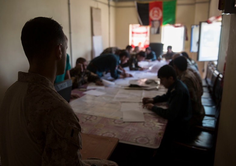 A U.S. Marine advisor with Task Force Southwest oversees Afghan National Defense and Security Force partners taking a map reading test at Bost Airfield, Afghanistan, July 16, 2017. The map reading class covered multiple areas including measuring straight and curved line distances, as well as being able to plot and pull a six-digit grid from a map. (U.S. Marine Corps photo by Justin T. Updegraff)