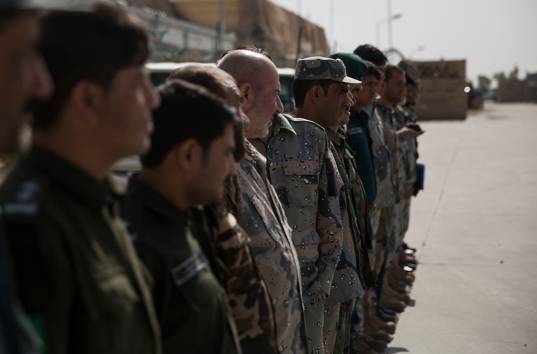 Afghan National Defense and Security Force partners stand in line as they wait to receive their graduation certificate, marking the end to the map reading class at Bost Airfield, Afghanistan, July 22, 2017. The map reading class covered multiple areas including measuring straight and curved line distances, as well as being able to plot and pull a six-digit grid from a map. (U.S. Marine Corps photo by Justin T. Updegraff)