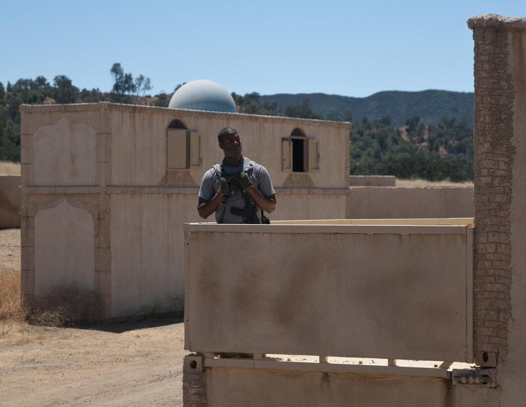 Army Reserve Spc. KC Short, a military police officer with the 96th Military Police Company, 96th Military Police Battalion, watches for an approaching U.S. Army Reserve Command convoy while roleplaying as an enemy combatant during a training exercise at Niscoln, a small mock village on Fort Hunter Liggett, Calif., July 20, 2017. The military police were sent to Fort Hunter Liggett to help test units training there as part of Combat Support Training Exercise 91-17-03. Nearly 5,400 service members from the U.S. Army Reserve Command, U.S. Army, Army National Guard, U.S. Navy, and Canadian Armed Forces are training at Fort Hunter Liggett as part of the 84th Training Command’s CSTX 91-17-03 and ARMEDCOM’s Global Medic; this is a unique training opportunity that allows U.S. Army Reserve units to train alongside their multi-component and joint partners as part of the America’s Army Reserve evolution into the most lethal Federal Reserve force in the history of the nation. (U.S. Army Reserve photo by Sgt. David L. Nye, 301st Public Affairs Detachment)