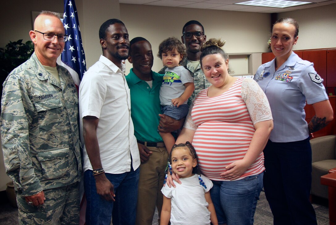 Family and friends gathered to witness a magical historical moment at the 932nd Airlift Wing, as Staff Sgt. Jamaine Smith (center, green shirt), crossed over "into the blue" from the United States Marines to the United States Air Force Reserve.  At left, the officer performing the oath of enlistment was Lt. Col. Stan Paregien, 932nd Chief of Public Affairs, and at far right, Sergeant Smith's recruiter that helped facilitate all his enlistment paperwork and guidance was Tech. Sgt. Brittany Paus, United States Air Force Reserve Line Recruiter.  Those interested in coming off active duty and becoming reservists are reminded to call the recruiters at (618)-229-7077 or toll free 1-800-257-1212.  The online "Get One Now" program is located at www.Get1Now.US for more information.  (U.S. Air Force photo by Senior Master Sgt. Melissa Melichar)