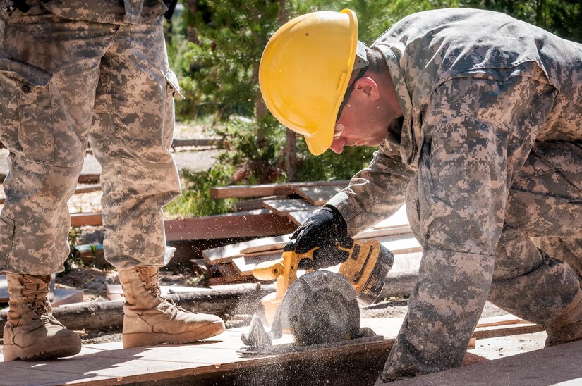 U.S. Army Reserve Spc. Gage Dean, a carpentry and masonry specialists with the 409th Engineer Company out of Fort Collins, Colorado, cuts siding during the construction of a large storage shed at the YMCA of the Rockies - Snow Mountain Ranch, in Granby, Colorado, July 17, 2017. (U.S. Army Reserve photo by Spc. Ce Shi, 222nd Broadcast Public Affairs Detachment)