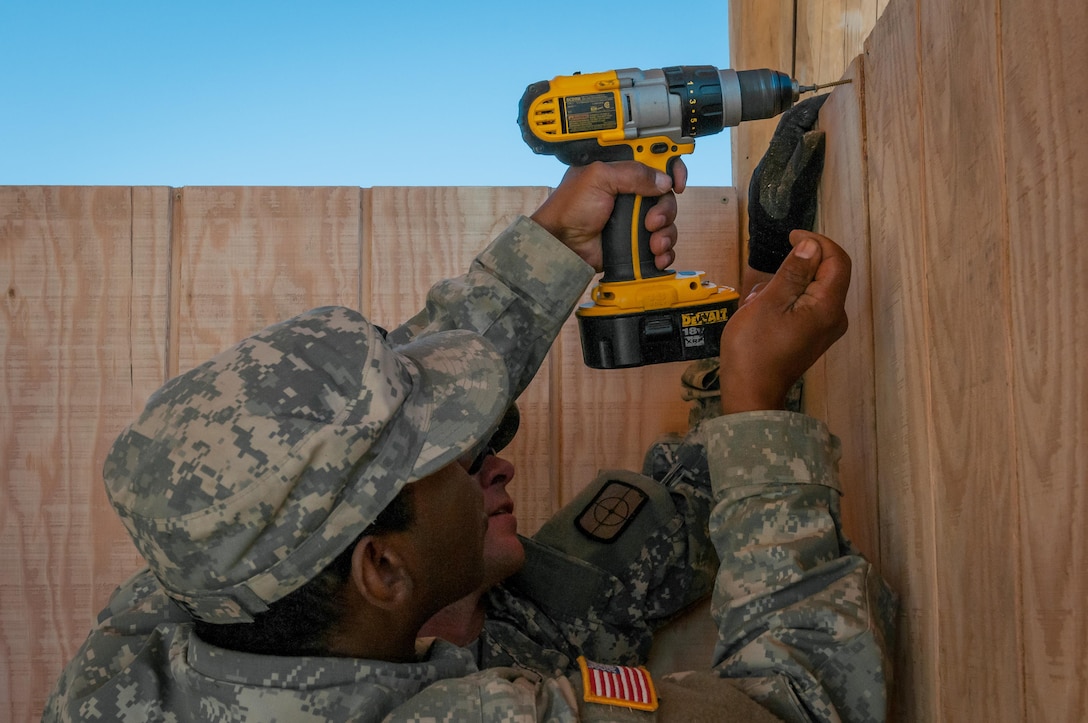 U.S. Army Reserve Spc. Michael Trice, a plumber, and Spc. Lance Coffman, in the rear, an interior electrician both of the 994th Engineer Company out of Denver, Colorado, install siding during the construction of a large storage shed at the YMCA of the Rockies-Snow Mountain Ranch, in Granby, Colorado, July 20, 2017. (U.S. Army Reserve photo by Spc. Miguel Alvarez, 354th Mobile Public Affairs Detachment)