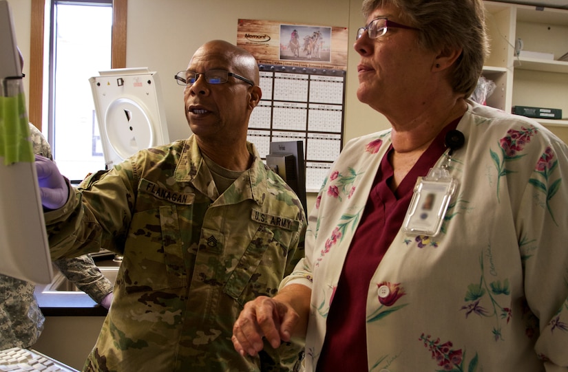 Staff Sgt. Phillip Flangan, a combat medic specialist with the 7239th Medical Support Unit, Chattanooga, Tennessee, works with Myrna Kampel, lead medical technologist at the Verne E. Gibbs Clinic at Poplar, Montana, as part of the Fort Peck Innovative Readiness Training, July 17, 2017. During the two-week-long mission, Army Reserve Soldiers will collaborate with the clinic staff providing medical and dental care to an estimated population of over 8,000 residents. (U.S. Army Reserve photo by Spc. Claudia Rocha 345th Public Affairs Detachment)