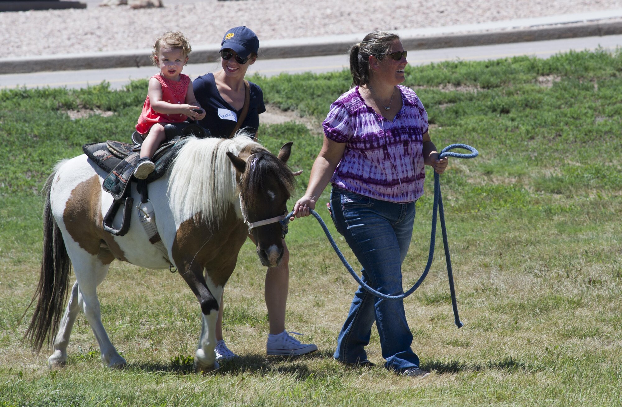 SCHRIEVER AIR FORCE BASE, Colo. -- Isabelle Scarlett Grissman, accompanied by her mom, Bonnie, rides a pony at Schriever's 2017 Summer Slam Picnic on Friday, July 21, 2017. Previous years offered elephant and camel rides to Airmen and their families, the ponies were a new addition to this years picnic. (U.S. Air Force photo/Senior Airman Laura Turner)
