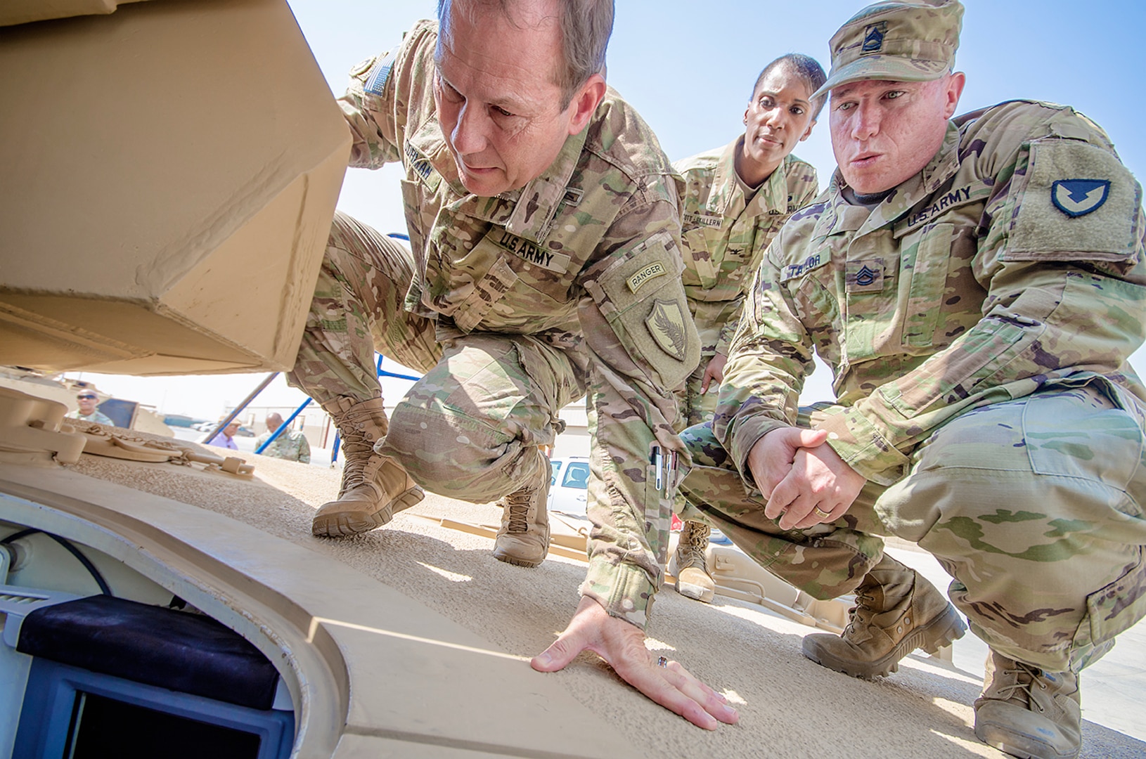 Maj. Gen. Edward Dorman (left), J-4 (logistics), U.S. Central Command, looks at a combat configured tank with Sgt. 1st Class Frank Taylor, contract officer representative, Army Field Support Battalion-Kuwait and Col. Carmelia Scott-Skillern, commander, 401st Army Field Support Brigade during a tour of an Army Prepositioned Stocks-5 warehouse at Camp Arifjan, Kuwait, July 20. (U.S. Army Photo by Justin Graff, 401st AFSB Public Affairs) (Photo Credit: U.S. Army)