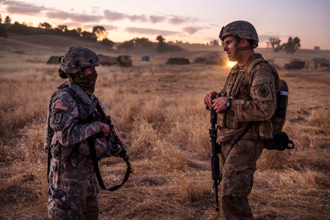 Army Reserve Cpl. Vanessa Lebold, left, and Spc. Jasper Devin discuss patrolling techniques after a reconnaissance patrol during a combat support training exercise at Fort Hunter Liggett, Calif., July 21, 2017. Lebold and Devin are military police officers assigned to the 56th Military Police Company. Army Reserve photo by Master Sgt. Michel Sauret 