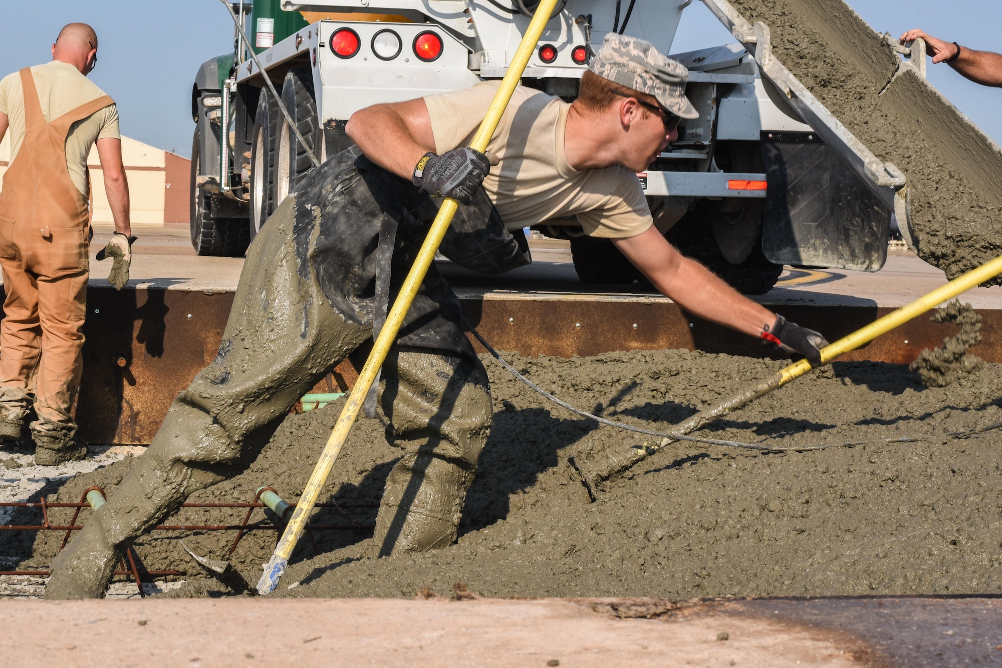 Staff Sgt. Zachary Aronin, assigned to the 2nd Civil Engineer Squadron Dirt Boyz, use rakes and shovels to spread wet concrete throughout a slab being fixed at Barksdale Air Force Base, La., July 18, 2017. The concrete replaced was over 35 years old. (U.S. Air Force Photo/Airman 1st Class Sydney Bennett)