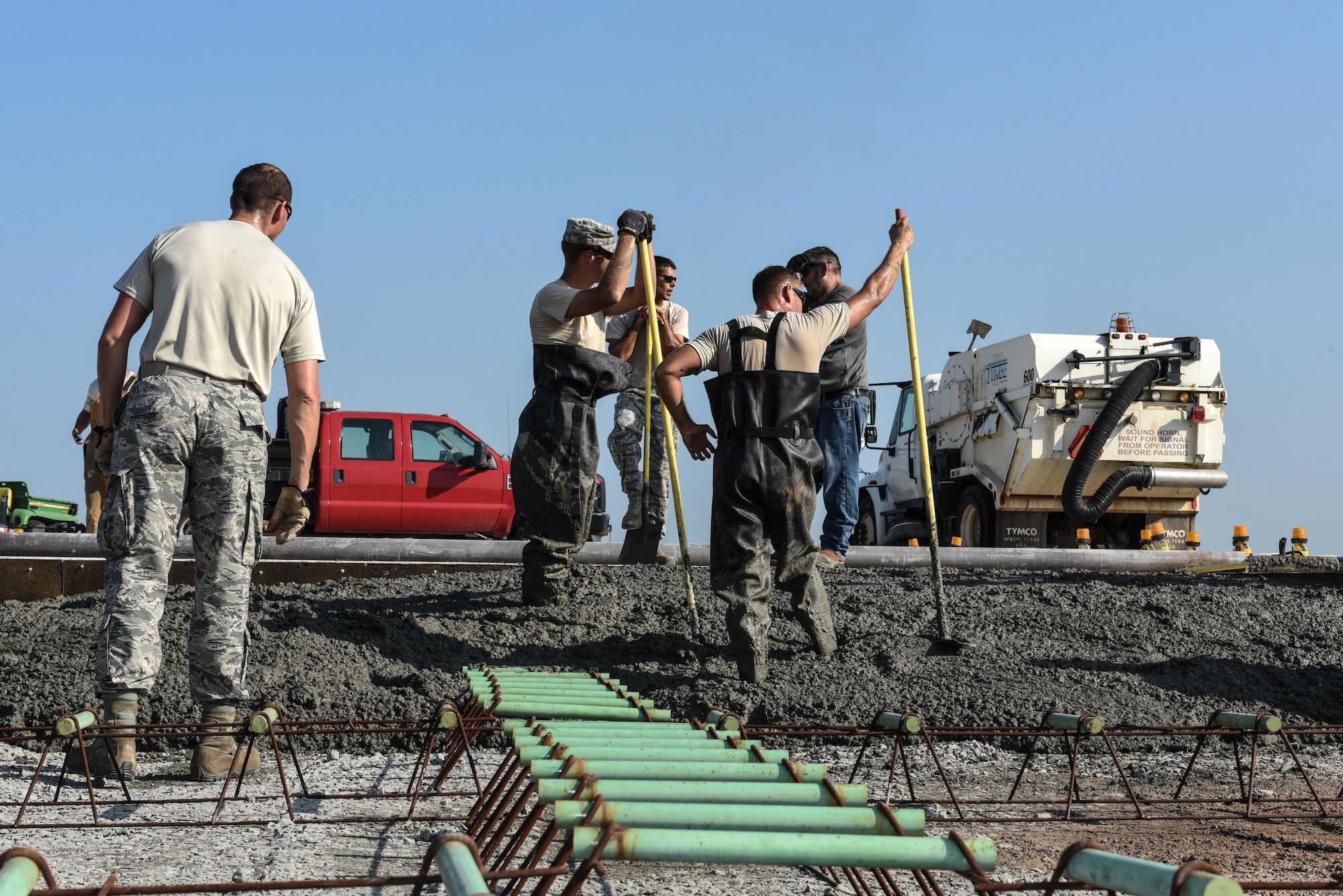 Dirt Boyz from the 2nd Civil Engineer Squadron wait for a concrete truck delivery at Barksdale Air Force Base, La., July 18, 2017. Each concrete truck contains approximately 10 yards worth of concrete. The open slab needed 106 yards. (U.S. Air Force Photo/Airman 1st Class Sydney Bennett)