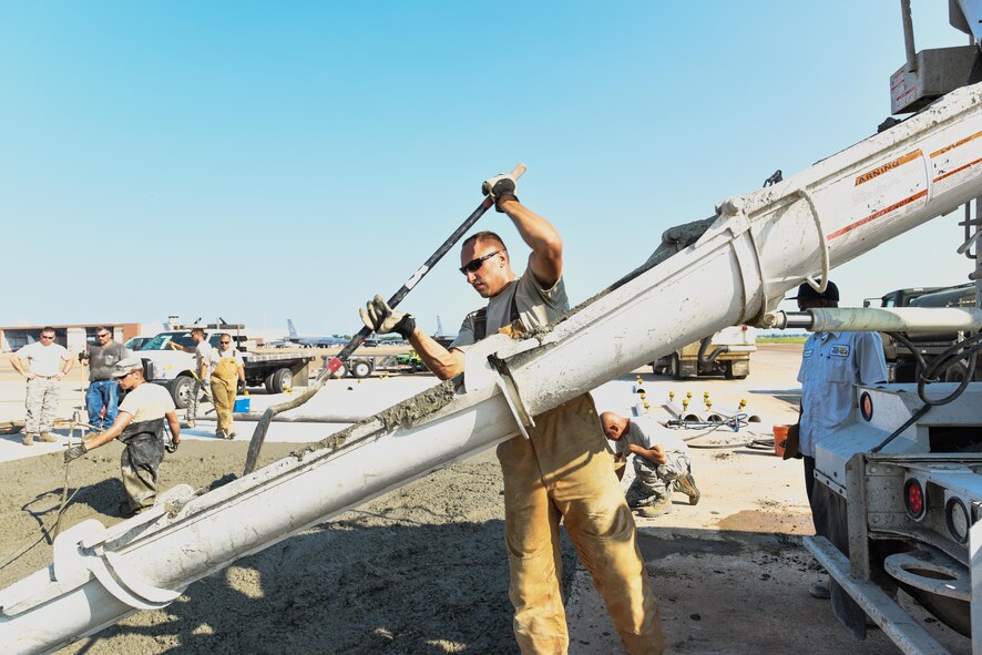 Staff Sgt. Cameron Kruell, assigned to the 2nd Civil Engineer Squadron Dirt Boyz, shovels wet concrete out of a truck at Barksdale Air Force Base, La., July 18, 2017. The team keeps the concrete in motion to prevent it from settling improperly. (U.S. Air Force Photo/Airman 1st Class Sydney Bennett)