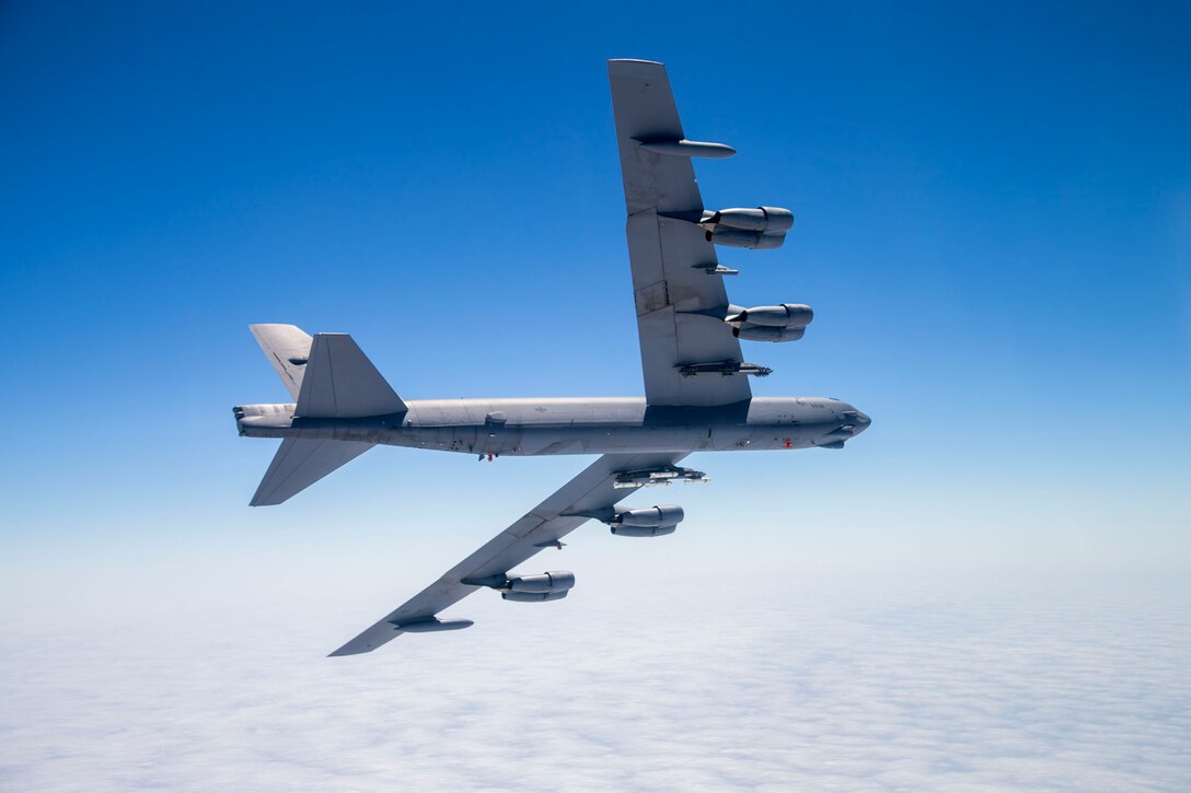 A B-52 Stratofortress assigned to the 419th Flight Test Squadron flies with eight PDU-5/B leaflet bombs connected to an external Heavy Stores Adapter Beam. (U.S. Air Force photo by Christopher Okula)
