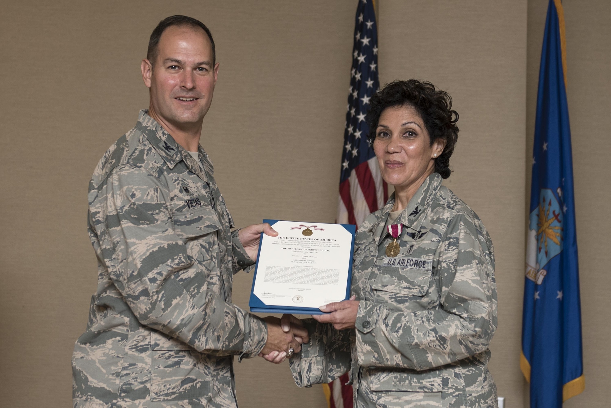 Col. Jay Vietas, 23d Medical Group commander, left, presents the Meritorious Service Medal to Col. Yvette Guzman, outgoing 23d Aerospace Medicine Squadron commander, during a change of command ceremony, July 20, 2017, at Moody Air Force Base, Ga. The change of command ceremony is a part of military history signifying the hand-off of responsibility of a unit from one commander to another. (U.S. Air Force photo by Airman 1st Class Destiney Masse)