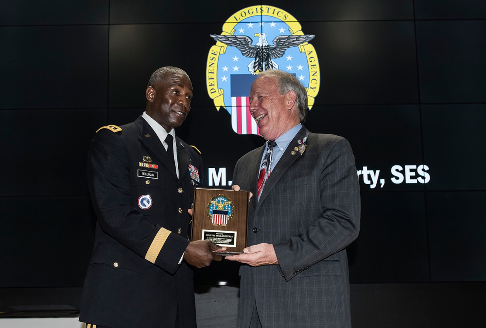 Defense Logistics Agency Director Army Lt. Gen. Darrell Williams presents DLA Land and Maritime Deputy Commander James McClaugherty with a retirement plaque commemorating his 47 years of federal service. The July 20 ceremony at Defense Supply Center Columbus honored McClaugherty for his contributions to the agency.