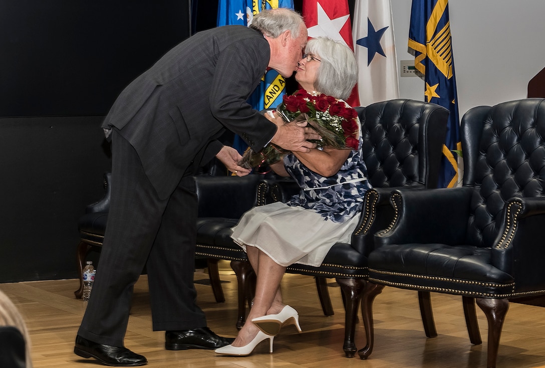 DLA Land and Maritime Deputy Commander James McClaugherty presents his wife Emerald with roses in acknowledgement of her patience as a partner during their careers and 23-year marriage. The couple’s anniversary fell on the same day as a retirement ceremony for McClaugherty at Defense Supply Center Columbus on July 20.