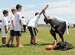 A volunteer football coach runs drills with participants during a youth football camp at Joint Base Langley-Eustis, Va., July 19, 2017. The camp was hosted in part with the youth programs, which offer different activities to educate, guide, and entertain military children within the JBLE community. (U.S. Air Force photo/Staff Sgt. Brittany E. N. Murphy)
