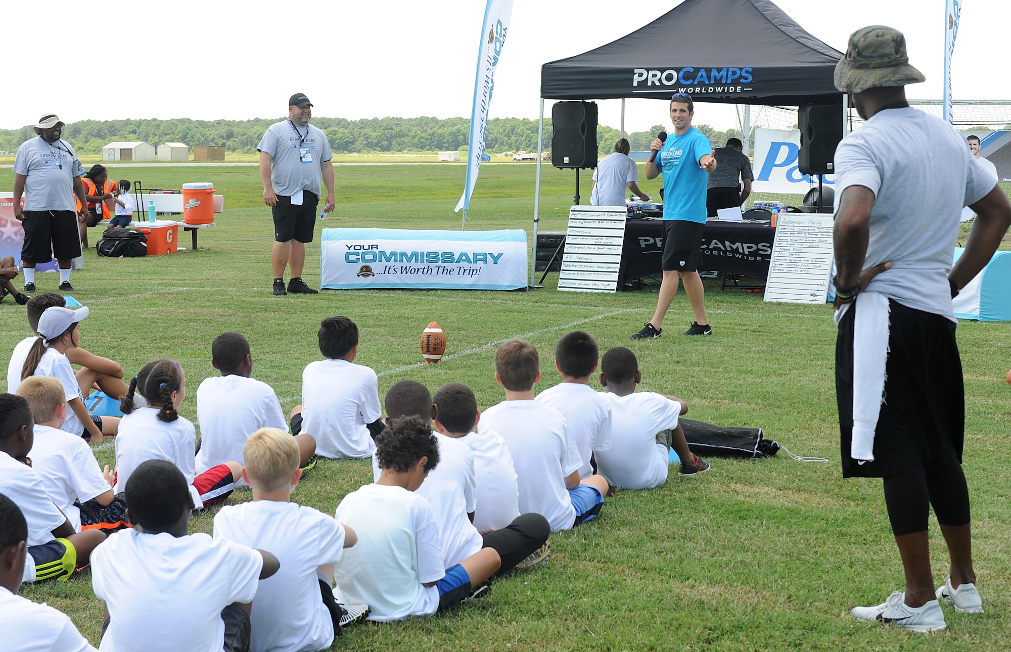 (Center) Graham Gano, Carolina Panthers placekicker, speaks to military children during the opening ceremony of a youth football camp at Joint Base Langley-Eustis, Va., July 19, 2017. As a military child himself, Gano felt that the ProCamp was a great opportunity to give back to children with a similar background. (U.S. Air Force photo/Staff Sgt. Brittany E. N. Murphy)