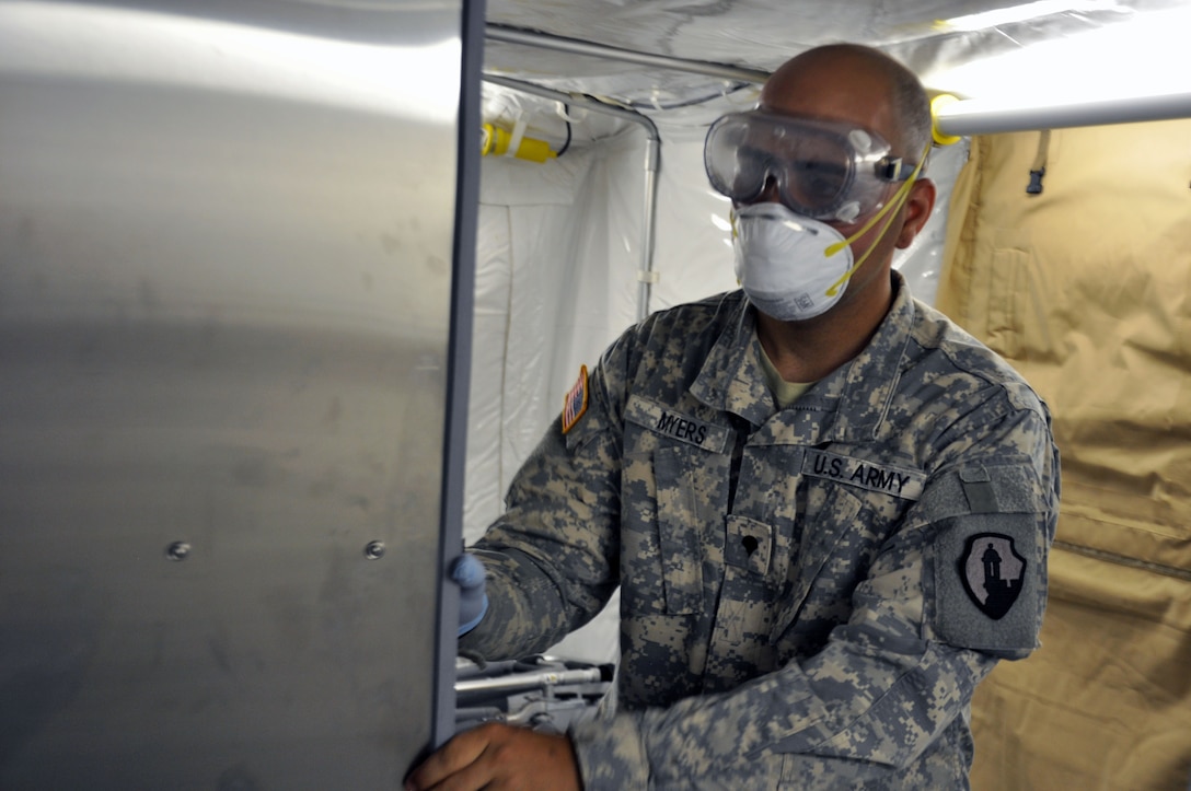 Spc. Christopher Myers, a mortuary affairs specialist with the 311th Quartermaster Company out Ramey Base, Puerto Rico, closes the door to a refrigeration unit inside a Mobile Integrated Remains Collection System at Fort Pickett, Virginia, July 16, 2017. The Army Reserve Soldier is participating in the 2017 Joint Mortuary Affairs Exercise along with active Army Soldiers, the Air Force and Marines.