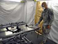 Spc. Christopher Myers, a mortuary affairs specialist with the 311th Quartermaster Company out Ramey Base, Puerto Rico, demonstrates the use of a special gurney, which is a component of the Mobile Integrated Remains Collection System at Fort Pickett, Virginia, July 16, 2017. The Army Reserve Soldier is participating in the 2017 Joint Mortuary Affairs Exercise along with active Army Soldiers, the Air Force and Marines.