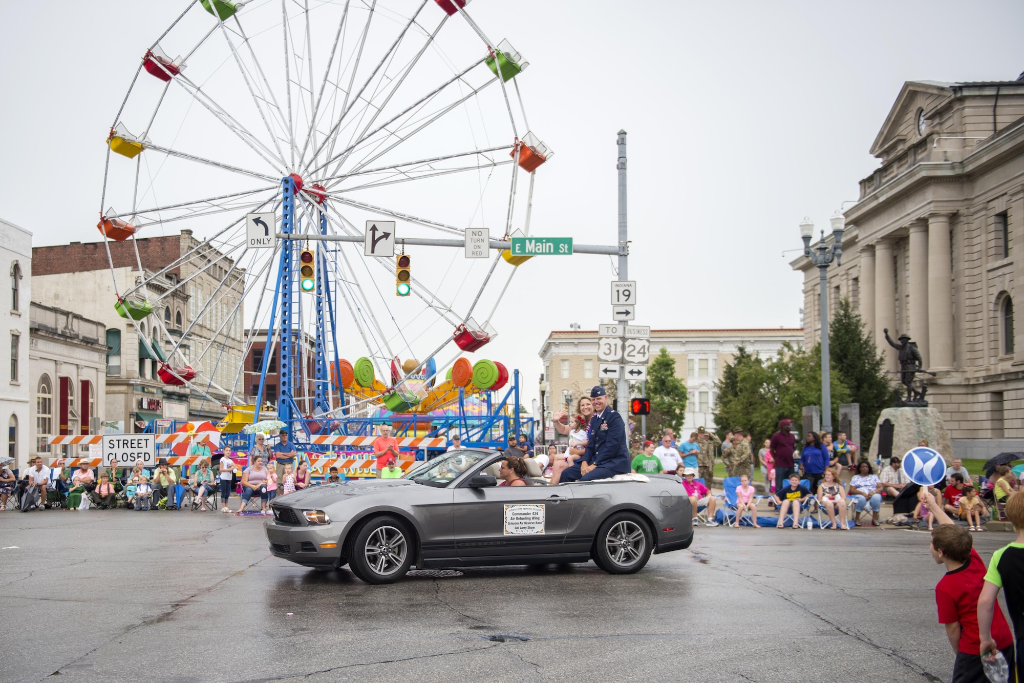 Col. Larry Shaw, 434th Air Refueling Wing commander, his spouse Kris, and granddaughter Lillian, smile and wave at spectators during the 58th Annual Circus City Festival parade in Peru, Ind. July 22, 2017. The parade is the world’s longest running circus parade and the second largest parade in Indiana. (U.S. Air Force photo/Tech. Sgt. Benjamin Mota)