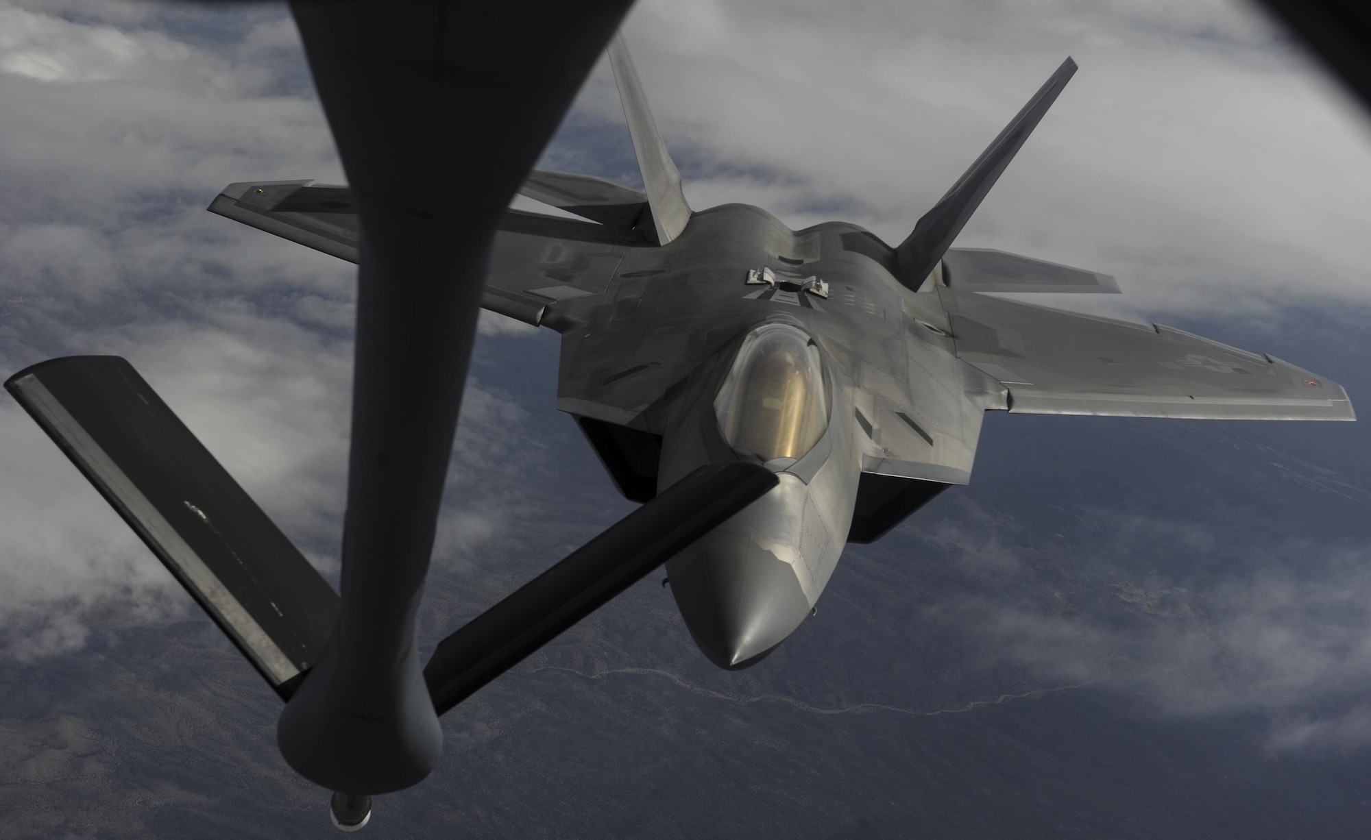 An F-22 Raptor fighter jet, assigned to the 433rd Weapons Squadron, at Nellis Air Force Base, flies to meet a KC-135 Stratotanker cargo aircraft assigned to the 509th Weapons Squadron, Fairchild Air Force Base, Washington, boom for aerial refueling over the Nevada Test and Training Range, Nev., July 10, 2017. The United States Air Force Weapons School teaches graduate-level instructor courses that provide the world's most advanced training in weapons and tactics employment to officers of the combat air forces and mobility air forces. (U.S. Air Force photo by Senior Airman Kevin Tanenbaum/Released)