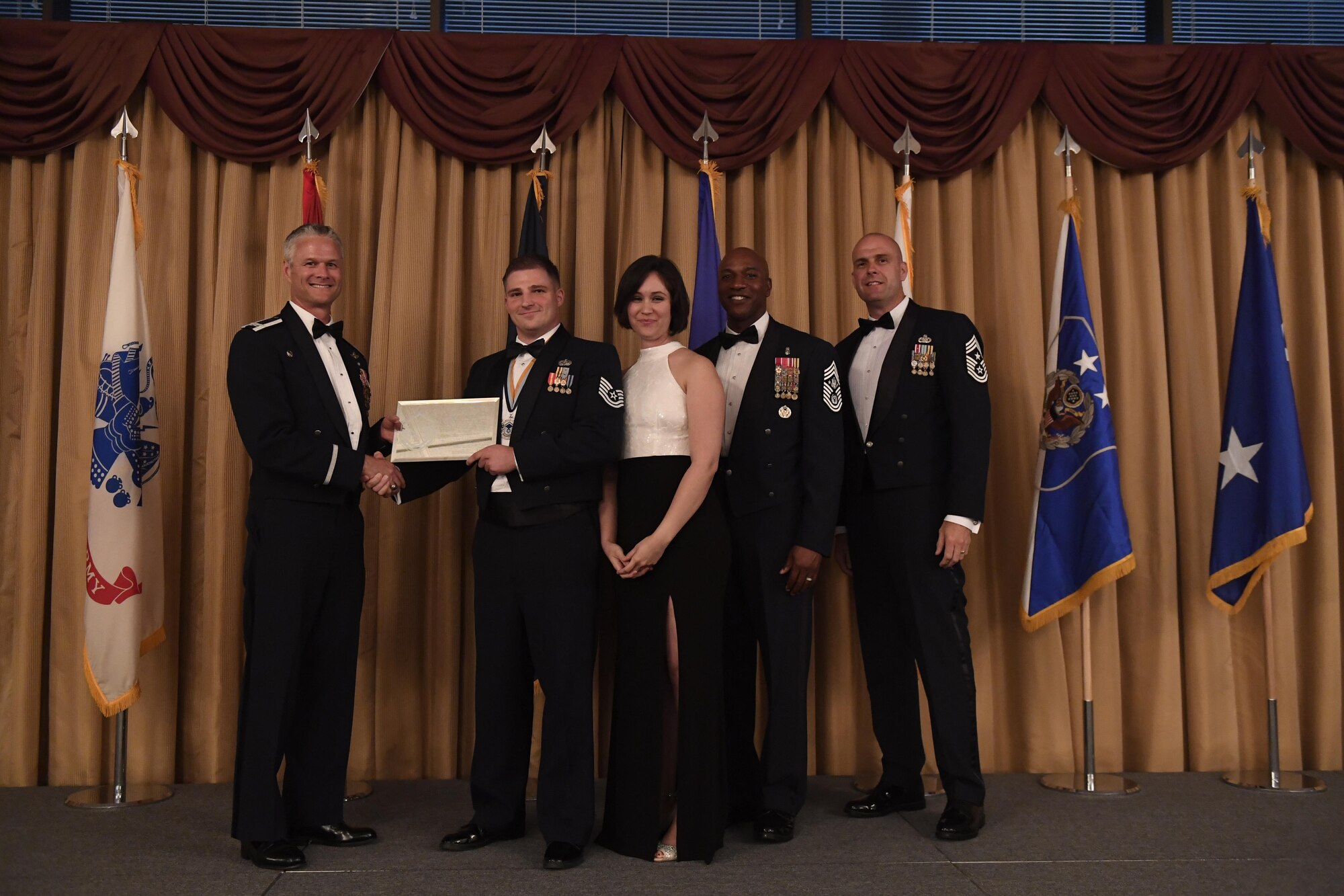 Col. Charles Henderson, 621st Contingency Response Wing commander and Chief Master Sgt. of the Air Force Kaleth O. Wright, issue a plaque to the Air Force's newest senior NCOs at the senior NCO induction on Joint Base McGuire-Dix-Lakehurst, New Jersey, July 21. Technical Sergeants recently selected for promotion to master sergeant were recognized at the event.