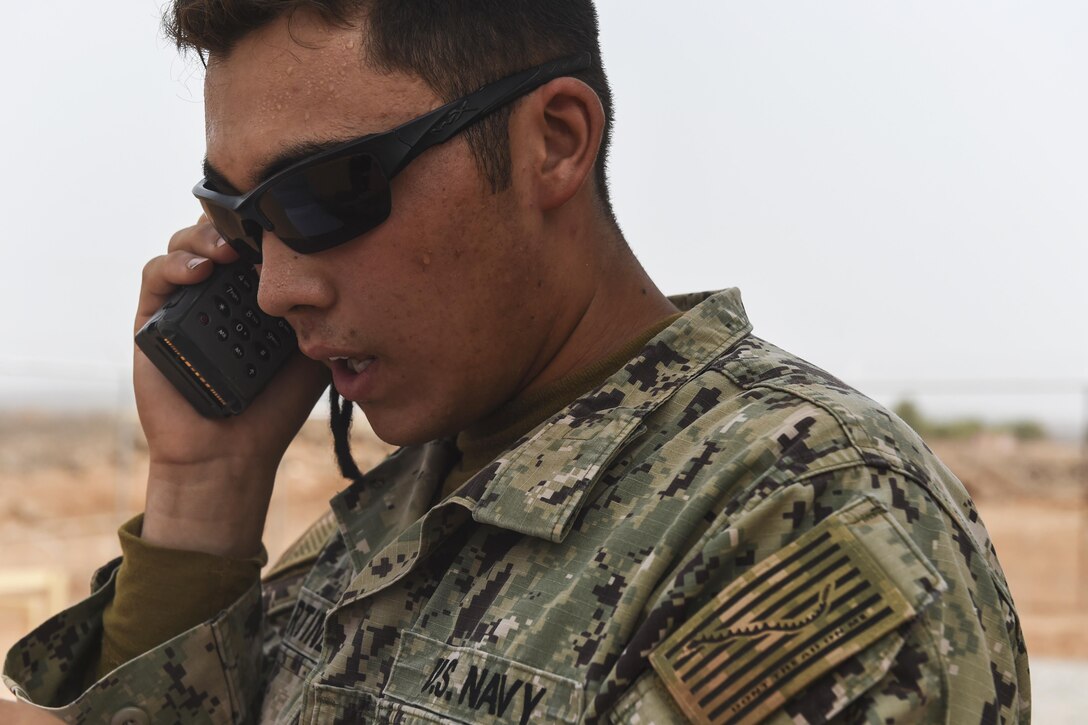 Navy Petty Officer 3rd Class Jesse Martinez uses a radio to call the French Air Force Tactical Airlift Squadron 88 for assistance with simulated medical evacuations during a bilateral exercise with French forces in the Arta region on Camp Lemonnier, Djibouti, July 19, 2017. Air Force photo by Staff Sgt. Eboni Prince