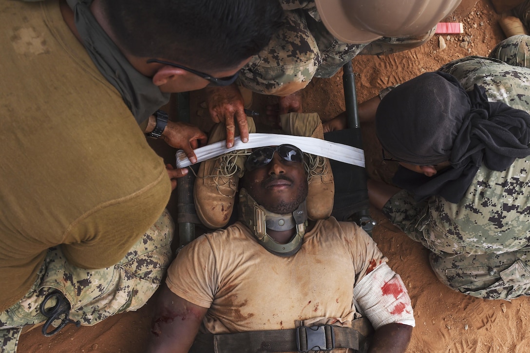 Navy Petty Officer 3rd Class Melvin Taylor receives care for his simulated injuries during a bilateral exercise with French forces in the Arta region on Camp Lemonnier, Djibouti, July 19, 2017. Air Force photo by Staff Sgt. Eboni Prince