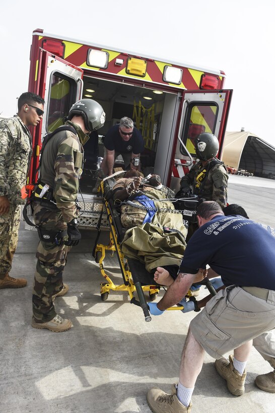 Emergency medical services personnel place a mock patient into an ambulance during a bilateral exercise with the Naval Mobile Construction Battalion One, a maneuver unit of the Combined Joint Task Force-Horn of Africa, and French forces on Camp Lemonnier, Djibouti, July 20, 2017. Air Force photo by Staff Sgt. Eboni Prince